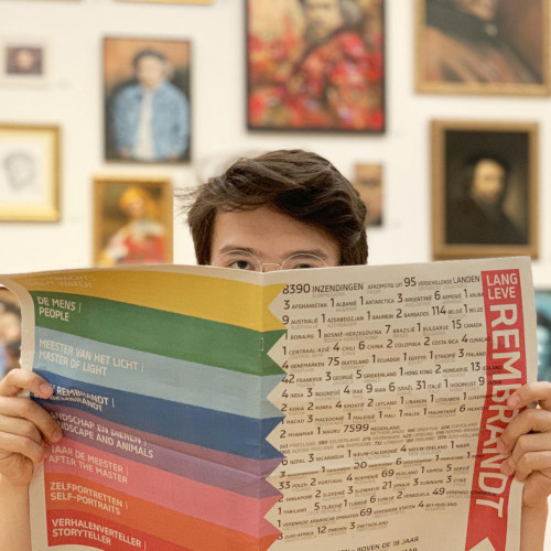 Max with a rainbow newspaper stating 'Lang Leve Rembrandt'